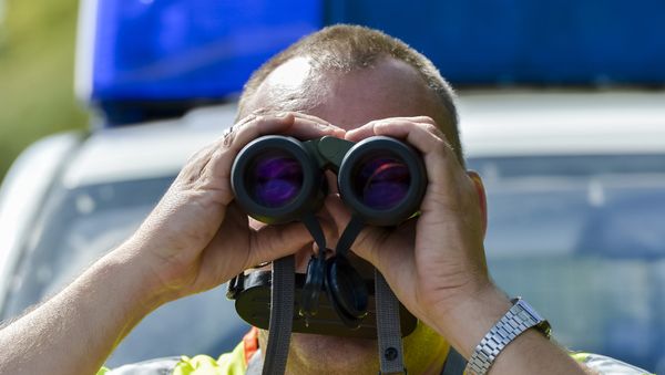 A police officer uses binoculars at a check point during control on the border crossing between Austria and Germany at the southern German city of Kiefersfelden on September 16, 2015 A police officer uses binoculars at a check point during control on the border crossing between Austria and Germany at the southern German city of Kiefersfelden on September 16, 2015 - Sputnik International
