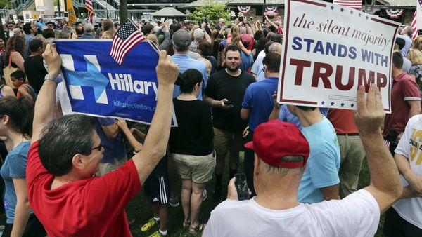 A supporter of Democratic presidential candidate Hillary Clinton and a Republican presidential candidate Donald Trump supporter hold signs as they attend a Memorial Day parade Monday, May 30, 2016, in Chappaqua, N.Y. Clinton and her husband former President Bill Clinton, along with New York Gov. Andrew Cuomo, walked in the parade A supporter of Democratic presidential candidate Hillary Clinton and a Republican presidential candidate Donald Trump supporter hold signs as they attend a Memorial Day parade Monday, May 30, 2016, in Chappaqua, N.Y. Clinton and her husband former President Bill Clinton, along with New York Gov. Andrew Cuomo, walked in the parade - Sputnik International
