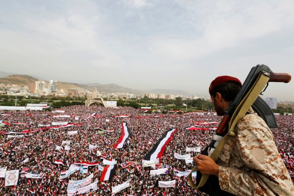 A soldier looks at people rallying to show support to a political council formed by the Houthi movement and the General People's Congress party to unilaterally rule Yemen by both groups, in the capital Sanaa August 20, 2016 - Sputnik International