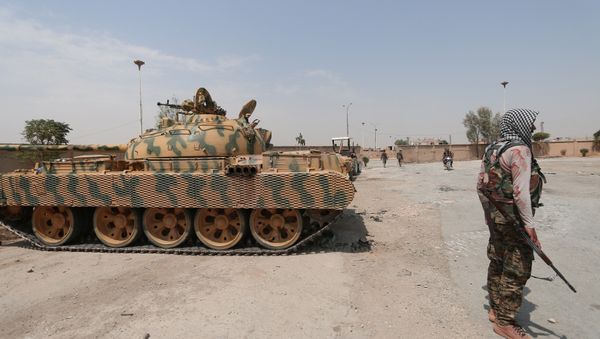 A Kurdish fighter from the People's Protection Units (YPG) carries his weapon as he stands past a tank in the Ghwairan neighborhood of Hasakah, Syria, August 22, 2016. A Kurdish fighter from the People's Protection Units (YPG) carries his weapon as he stands past a tank in the Ghwairan neighborhood of Hasakah, Syria, August 22, 2016. - Sputnik International
