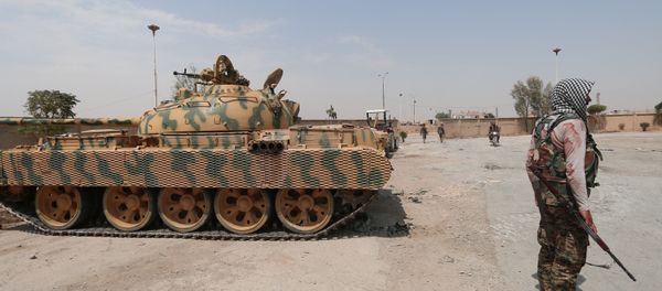 A Kurdish fighter from the People's Protection Units (YPG) carries his weapon as he stands past a tank in the Ghwairan neighborhood of Hasakah, Syria, August 22, 2016. A Kurdish fighter from the People's Protection Units (YPG) carries his weapon as he stands past a tank in the Ghwairan neighborhood of Hasakah, Syria, August 22, 2016. - Sputnik International