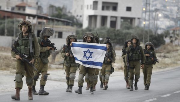 Israeli soldiers holding their national flag patrol a street in the West Bank village of Beit Furik, southeast of Nablus, early on June 20, 2014. - Sputnik International