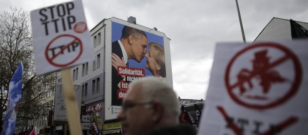 A man holds a poster with the slogan Stop TTIP as he passes a huge poster against TTIP with President Barack Obama and Chancellor Angela Merkel during a protest of thousands of demonstrators against the planned Transatlantic Trade and Investment Partnership, TTIP, and the Comprehensive Economic and Trade Agreement, CETA, ahead of the visit of United States President Barack Obama in Hannover, Germany, Saturday, April 23, 2016 A man holds a poster with the slogan Stop TTIP as he passes a huge poster against TTIP with President Barack Obama and Chancellor Angela Merkel during a protest of thousands of demonstrators against the planned Transatlantic Trade and Investment Partnership, TTIP, and the Comprehensive Economic and Trade Agreement, CETA, ahead of the visit of United States President Barack Obama in Hannover, Germany, Saturday, April 23, 2016 - Sputnik International