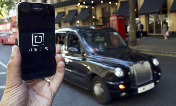 A photo illustration shows the Uber app logo displayed on a mobile telephone, as it is held up for a posed photograph in central London, Britain August 17, 2016. - Sputnik International