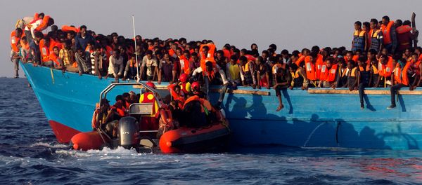 A rescue boat of the Spanish NGO Proactiva approaches an overcrowded wooden vessel with migrants from Eritrea, off the Libyan coast in Mediterranean Sea August 29, 2016 - Sputnik International