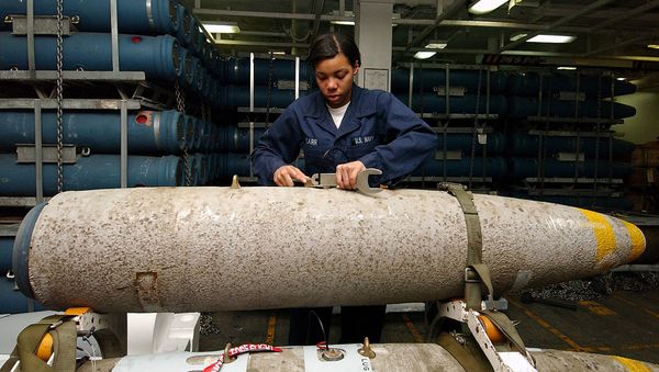 An aviation ordnance technician handling the bomb body of a thermally protected (insulated to slow cook-off time in case of fire) Mark 84 aboard the USS George Washington. - Sputnik International