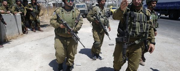Israeli soldiers are seen at the site of a stabbing attack by a Palestinian man next to the entrance of the al-Arub refugee camp near the city of Hebron in the Israeli-occupied West Bank on July 18, 2016 - Sputnik International