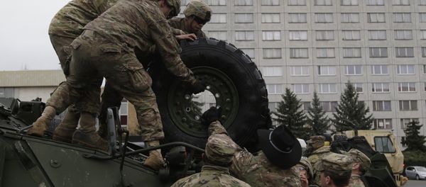 US army soldiers roll a tyre from top of a stryker armored vehicle during a stop of his convoy in Prague, Czech Republic, Tuesday, March 31, 2015 - Sputnik International