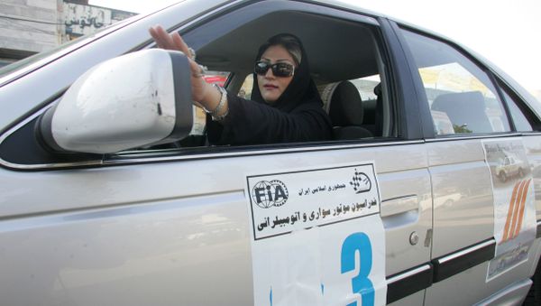 An Iranian driver adjusts her side mirror at the start of the women's rally in the northern Iranian city of Chalus 05 September 2007 - Sputnik International