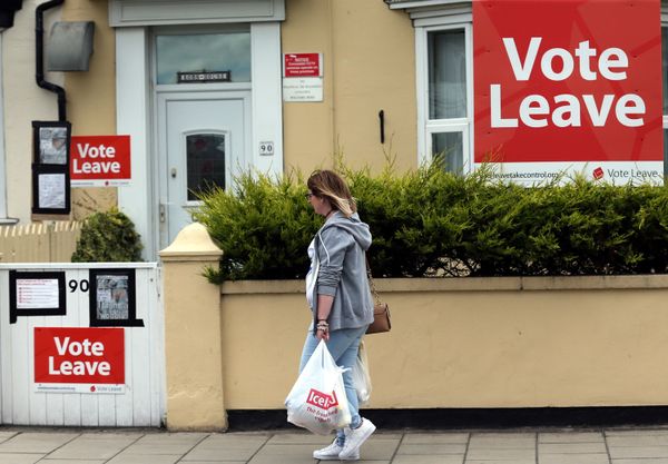 A woman walks past a house where Vote Leave boards are displayed in Redcar, north east England on June 27, 2016. - Sputnik International
