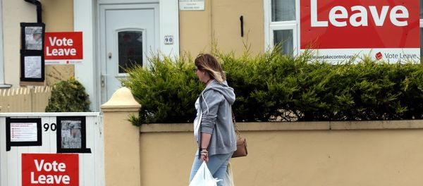 A woman walks past a house where Vote Leave boards are displayed in Redcar, north east England on June 27, 2016. - Sputnik International