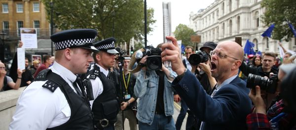 Police stand in a cordon as a pro-Europe (R) marcher on a March for Europe demonstration against the Brexit vote in Parliament Square in central London - Sputnik International