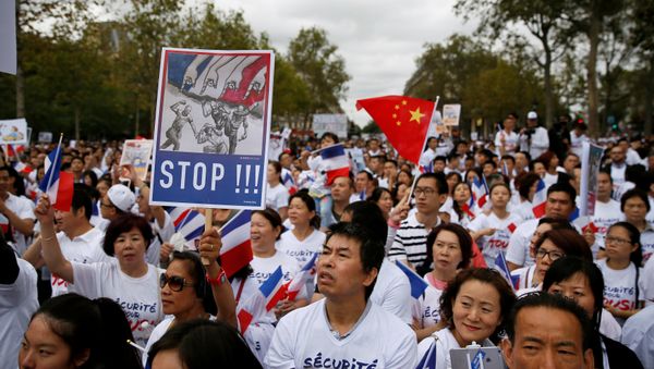 Demonstrators hold signs at a rally of the Chinese community to raise awareness about recent racists attacks in Paris, France, September 4, 2016. Demonstrators hold signs at a rally of the Chinese community to raise awareness about recent racists attacks in Paris, France, September 4, 2016. - Sputnik International