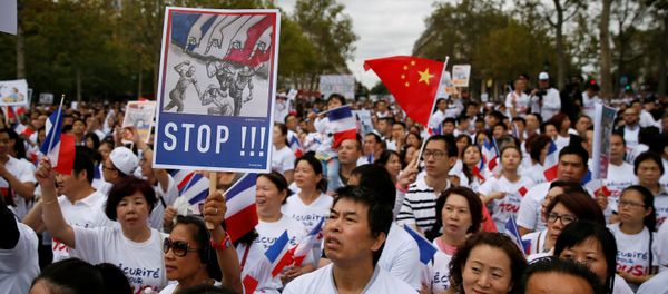 Demonstrators hold signs at a rally of the Chinese community to raise awareness about recent racists attacks in Paris, France, September 4, 2016. Demonstrators hold signs at a rally of the Chinese community to raise awareness about recent racists attacks in Paris, France, September 4, 2016. - Sputnik International