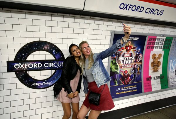 Passengers pose for a selfie as they wait for the Night Tube train service at Oxford Circus on the London underground system in London, Britain August 20, 2016. - Sputnik International