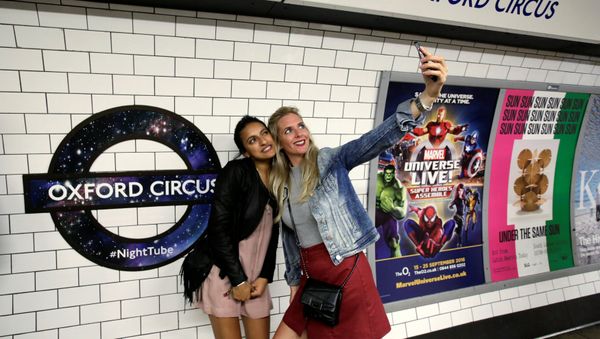 Passengers pose for a selfie as they wait for the Night Tube train service at Oxford Circus on the London underground system in London, Britain August 20, 2016. - Sputnik International