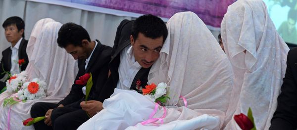 In this photograph taken on October 10, 2014, an Afghan groom (C) talks with his bride during a mass wedding ceremony in which one hundred couples were married on the outskirts of Kabul In this photograph taken on October 10, 2014, an Afghan groom (C) talks with his bride during a mass wedding ceremony in which one hundred couples were married on the outskirts of Kabul - Sputnik International