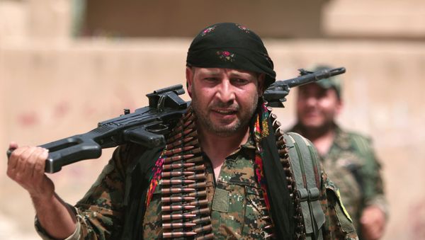 A Kurdish fighter from the People's Protection Units (YPG) carries his weapons as he walks along a street in the northeastern city of Hasaka, Syria, August 21, 2016. - Sputnik International