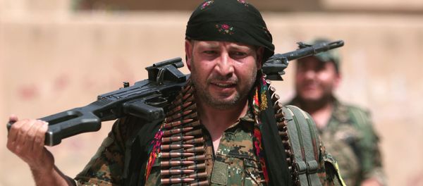 A Kurdish fighter from the People's Protection Units (YPG) carries his weapons as he walks along a street in the northeastern city of Hasaka, Syria, August 21, 2016. - Sputnik International