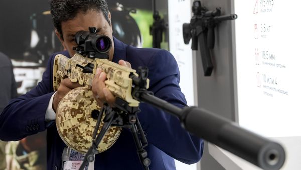 A visitor reviews an RPK-16 light machine rifle at the Kalashnikov pavilion, at the ARMY 2016 International Military Forum, at the exhibition center of the Patriot Military Park of the Russian Armed Forces in the Moscow Region. - Sputnik International