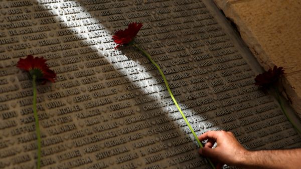 A man lays a flower on a monument engraved with names of victims of the September 11th attacks, during a memorial event marking the 15th anniversary of September 11, 2001 attacks in the U.S., at the 9/11 Living Memorial Plaza in Jerusalem - Sputnik International