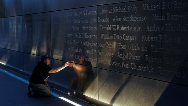 A mourner places a flag in the Empty Sky memorial on the morning of the 15th anniversary of the 9/11 attacks in New Jersey, U.S - Sputnik International