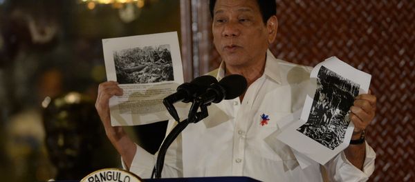 Philippine President Rodrigo Duterte holds up a photo and cites accounts of US troops who killed Muslims during the US's occupation of the Philippines in the early-1900s, during a speech at the Malacanang palace in Manila on September 12, 2016. Philippine President Rodrigo Duterte holds up a photo and cites accounts of US troops who killed Muslims during the US's occupation of the Philippines in the early-1900s, during a speech at the Malacanang palace in Manila on September 12, 2016. - Sputnik International