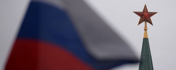 A spire of a Moscow Kremlin tower and a Russian flag on Red Square - Sputnik International
