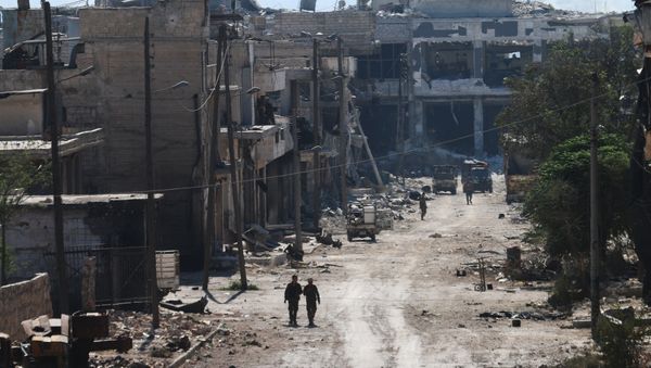 Syrian pro-regime fighters walk in a bombed-out steet in Ramussa on September 9, 2016, after they took control of the strategically important district on the outskirts of the Syrian city of Aleppo yesterday - Sputnik International