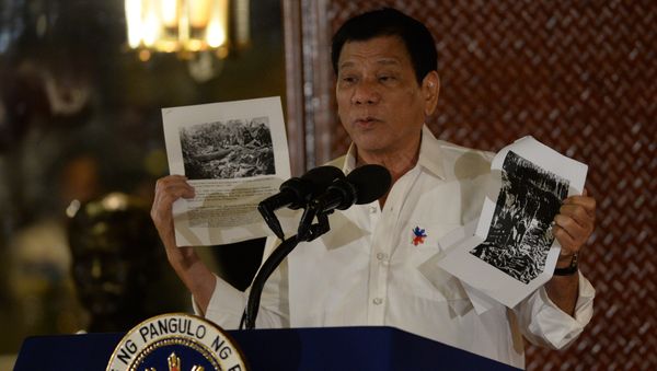 Philippine President Rodrigo Duterte holds up a photo and cites accounts of US troops who killed Muslims during the US's occupation of the Philippines in the early-1900s, during a speech at the Malacanang palace in Manila on September 12, 2016 Philippine President Rodrigo Duterte holds up a photo and cites accounts of US troops who killed Muslims during the US's occupation of the Philippines in the early-1900s, during a speech at the Malacanang palace in Manila on September 12, 2016 - Sputnik International