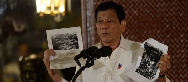 Philippine President Rodrigo Duterte holds up a photo and cites accounts of US troops who killed Muslims during the US's occupation of the Philippines in the early-1900s, during a speech at the Malacanang palace in Manila on September 12, 2016 Philippine President Rodrigo Duterte holds up a photo and cites accounts of US troops who killed Muslims during the US's occupation of the Philippines in the early-1900s, during a speech at the Malacanang palace in Manila on September 12, 2016 - Sputnik International