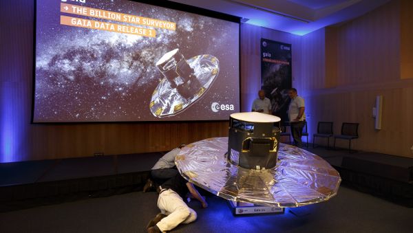 Scientists look under a scaled reproduction of the GAIA surveyor at an event of the European Space Agency, or ESA, to release the first data on its GAIA mission to make a space map, at the ESA center in Villanueva de la Canada, near Madrid, Spain, Wednesday, Sept. 14, 2016 - Sputnik International