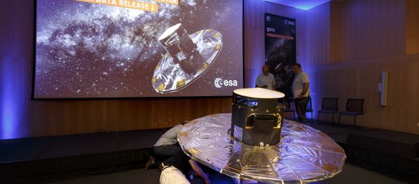 Scientists look under a scaled reproduction of the GAIA surveyor at an event of the European Space Agency, or ESA, to release the first data on its GAIA mission to make a space map, at the ESA center in Villanueva de la Canada, near Madrid, Spain, Wednesday, Sept. 14, 2016 - Sputnik International