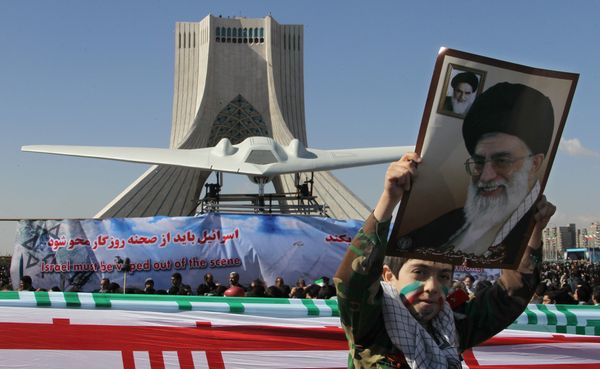 An Iranian boy holds a portrait of supreme leader, Ayatollah Ali khamenei as he walks past a replica of the captured US RQ-170 drone on display next to the Azadi (Freedom) tower during the 33rd anniversary of the Islamic revolution in Tehran on February 11, 2012 An Iranian boy holds a portrait of supreme leader, Ayatollah Ali khamenei as he walks past a replica of the captured US RQ-170 drone on display next to the Azadi (Freedom) tower during the 33rd anniversary of the Islamic revolution in Tehran on February 11, 2012 - Sputnik International