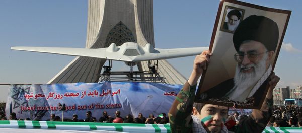 An Iranian boy holds a portrait of supreme leader, Ayatollah Ali khamenei as he walks past a replica of the captured US RQ-170 drone on display next to the Azadi (Freedom) tower during the 33rd anniversary of the Islamic revolution in Tehran on February 11, 2012 An Iranian boy holds a portrait of supreme leader, Ayatollah Ali khamenei as he walks past a replica of the captured US RQ-170 drone on display next to the Azadi (Freedom) tower during the 33rd anniversary of the Islamic revolution in Tehran on February 11, 2012 - Sputnik International
