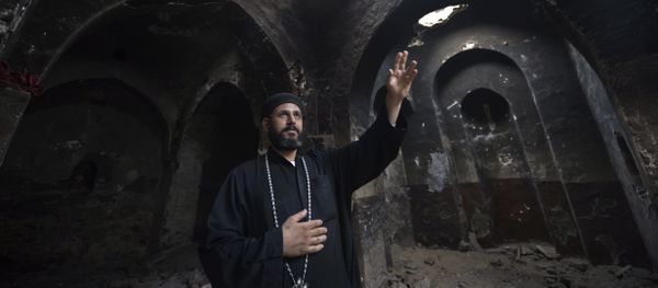 Delga's Coptic priest Yuannas points at the damage in the historical Blessed Virgin church following an attack by masked Islamist men the previous month in the town of Delga, in the central Egyptian province of Minya, some of 400 kilometres south of Cairo, on September 29, 2013 Delga's Coptic priest Yuannas points at the damage in the historical Blessed Virgin church following an attack by masked Islamist men the previous month in the town of Delga, in the central Egyptian province of Minya, some of 400 kilometres south of Cairo, on September 29, 2013 - Sputnik International