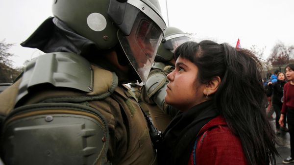 A demonstrator looks at a riot policeman during a protest marking the country's 1973 military coup in Santiago, Chile September 11, 2016.  - Sputnik International
