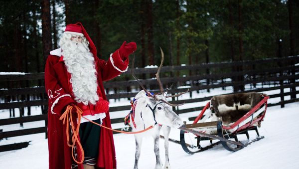 Santa Claus waves as he stands with a reindeer and sled outside Rovaniemi, Finnish Lapland on December 15, 2011 Santa Claus waves as he stands with a reindeer and sled outside Rovaniemi, Finnish Lapland on December 15, 2011 - Sputnik International