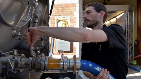 An employee of De Halve Maan brewery connects a pipe to feed beer into a truck in Bruges, September 15, 2016 An employee of De Halve Maan brewery connects a pipe to feed beer into a truck in Bruges, September 15, 2016 - Sputnik International