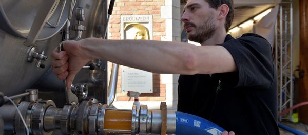 An employee of De Halve Maan brewery connects a pipe to feed beer into a truck in Bruges, September 15, 2016 - Sputnik International
