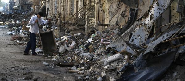 A Syrian child clears debris from a street in the northeastern city of Deir Ezzor A Syrian child clears debris from a street in the northeastern city of Deir Ezzor - Sputnik International