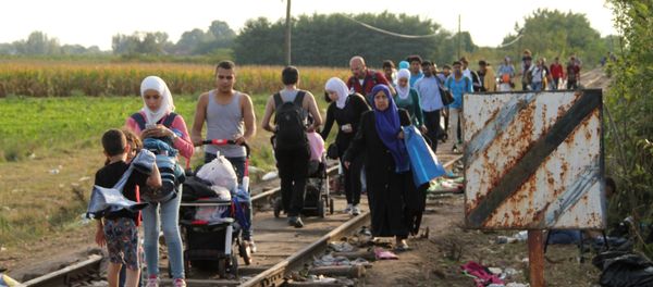 Refugees who did not cross the border before its closure walk on railroad tracks by the Serbian-Hungarian border near the village of Reske - Sputnik International