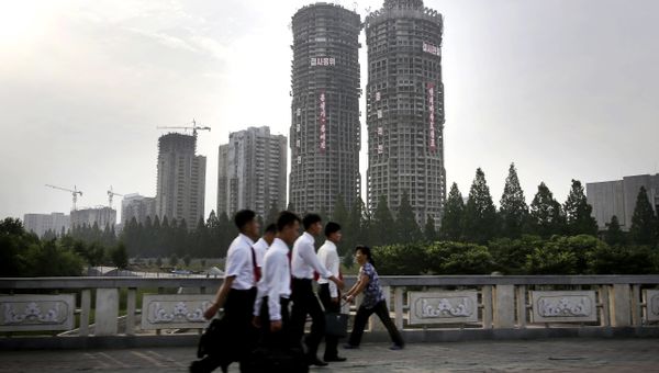 In this June 27, 2016, photo, North Korean men and women walk past buildings under construction on “Ryomyong Street,” in Pyongyang, North Korea - Sputnik International