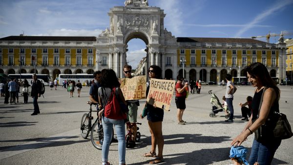 People hold posters welcoming refugees during a rally in support of migrants and refugees as part of the European Day of Action in Lisbon (File) People hold posters welcoming refugees during a rally in support of migrants and refugees as part of the European Day of Action in Lisbon (File) - Sputnik International
