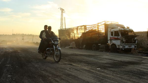 Men drive a motorcycle near a damaged aid truck after an airstrike on the rebel held Urm al-Kubra town, western Aleppo city, Syria September 20, 2016 Men drive a motorcycle near a damaged aid truck after an airstrike on the rebel held Urm al-Kubra town, western Aleppo city, Syria September 20, 2016 - Sputnik International