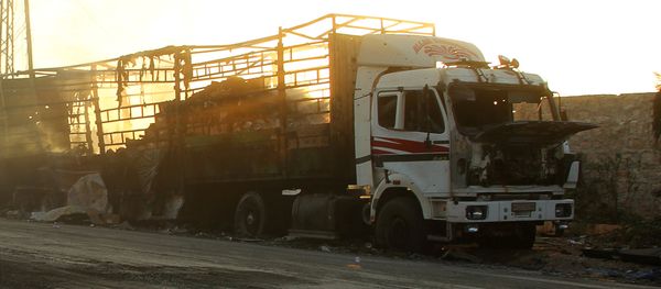 Men drive a motorcycle near a damaged aid truck after an airstrike on the rebel held Urm al-Kubra town, western Aleppo city, Syria September 20, 2016 - Sputnik International