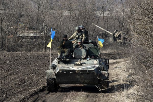 Ukrainian servicemen ride atop armored vehicle with a canon in tow and Ukrainian flags, near the village of Fedorivka, eastern Ukraine, Friday, Feb. 27, 2015 - Sputnik International