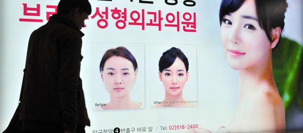 A pedestrian walks past an advertisement for plastic surgery clinic at a subway station in Seoul on March 26, 2014 - Sputnik International