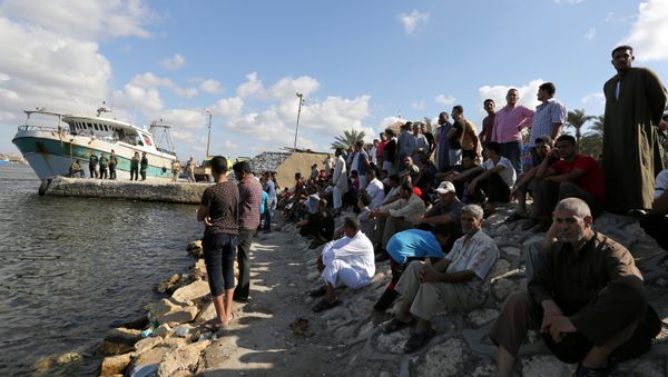 People gather along the shore of the Mediterranean Sea during a search for victims after a migrant boat capsized, in Al-Beheira, Egypt, September 22, 2016 - Sputnik International