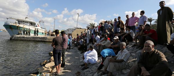 People gather along the shore of the Mediterranean Sea during a search for victims after a migrant boat capsized, in Al-Beheira, Egypt, September 22, 2016 - Sputnik International